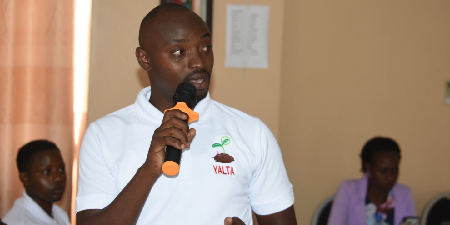 A youth speakig about issues affectig them durig the cosultative meetig